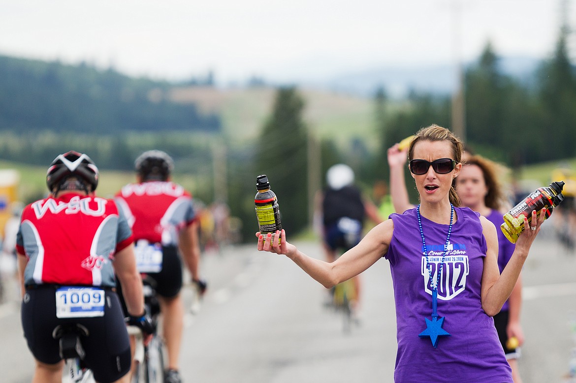 SHAWN GUST/Press file
Volunteer Jenn Peters, of Post Falls, hands out drinks at a bike aid station during the 2012 Ironman Coeur d&#146;Alene.