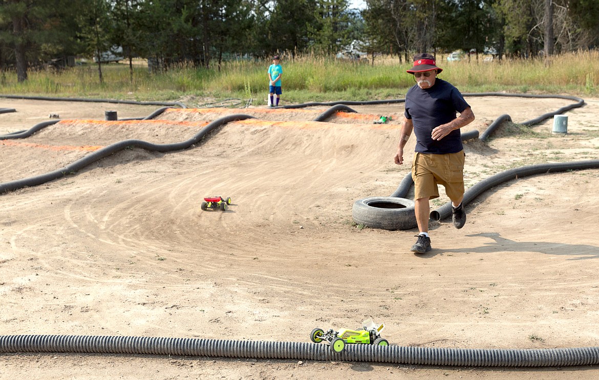 Jim Dennis hurries to free a car stuck on the raceway.