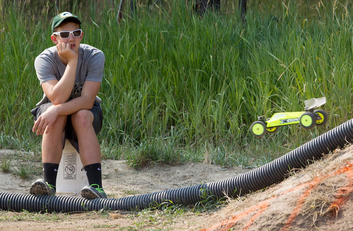 Cayman Lee watches a remote-control race car pass. His task is to get cars back on the track after crashes. (John Blodgett/The Western News)