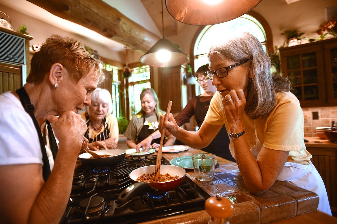 Penny Carpenter watches as Nancy Biddle heats spice mixes at the Indian Spice workshop with Julie Laing from Twice as Tasty on July 10 in Whitefish. In the background are Kathy Trautman, Glenda Smith and Laing. (Brenda Ahearn photos/Daily Inter Lake)