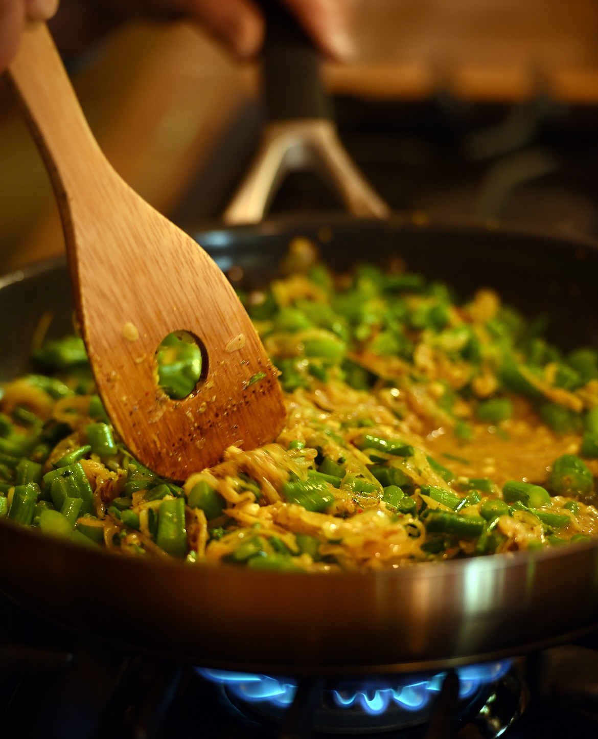 A skillet full of broccoli, onions, garlic and freshly made curry spice simmers.