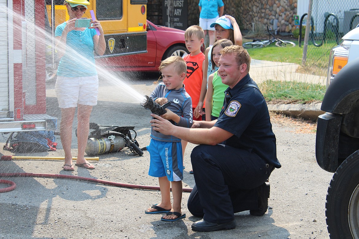 Firefighter Andersen lets one of the students shoot the firehose.