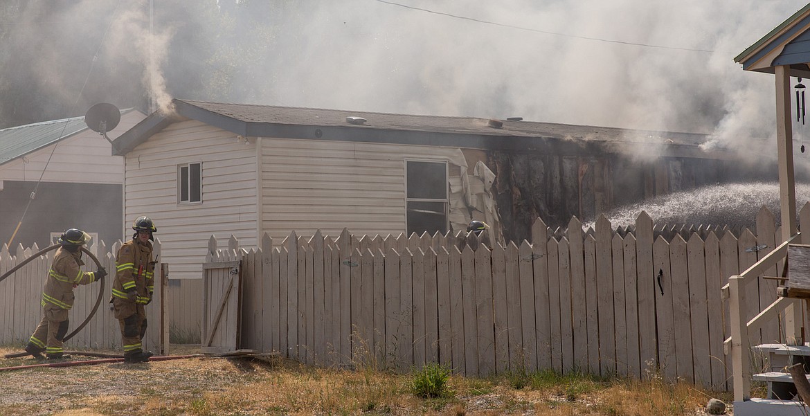 Above: Libby Volunteer firefighters battle a mobile home fire on Crossway Avenue in Libby Wednesday, Aug. 2. (John Blodgett/The Western News)