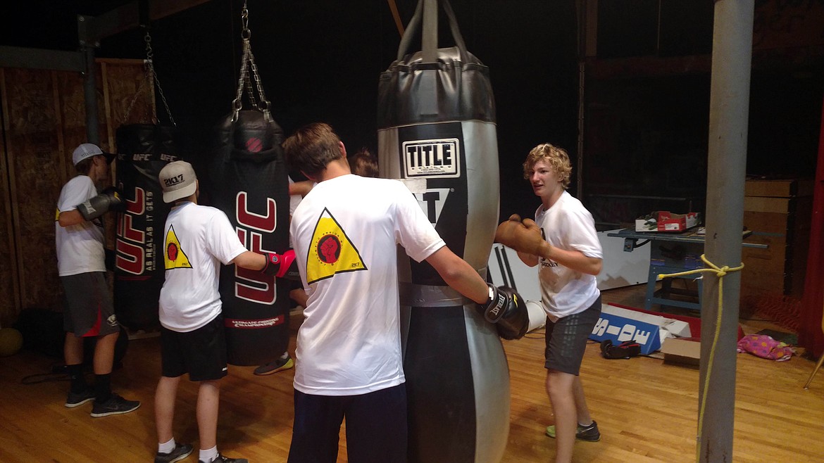 Campers work on power punching with the heavy bags during a boxing session.