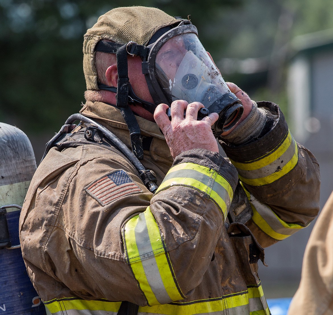 Libby Volunteer Firefighter Scott Beagle prepares to enter a burning mobile home on Crossway Avenue in Libby Wednesday, Aug. 2, 2017. See more photos on page B1. (John Blodgett/The Western News)