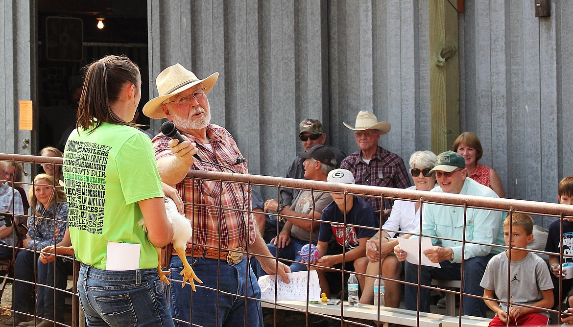 Danielle VanderPloeg talks to auctioneer, Jim Ellis about her broiler chickens. It&#146;s the first time in nearly 10 years that chickens were auctioned and they fetched $1,600. (Kathleen Woodford/Mineral Independent).