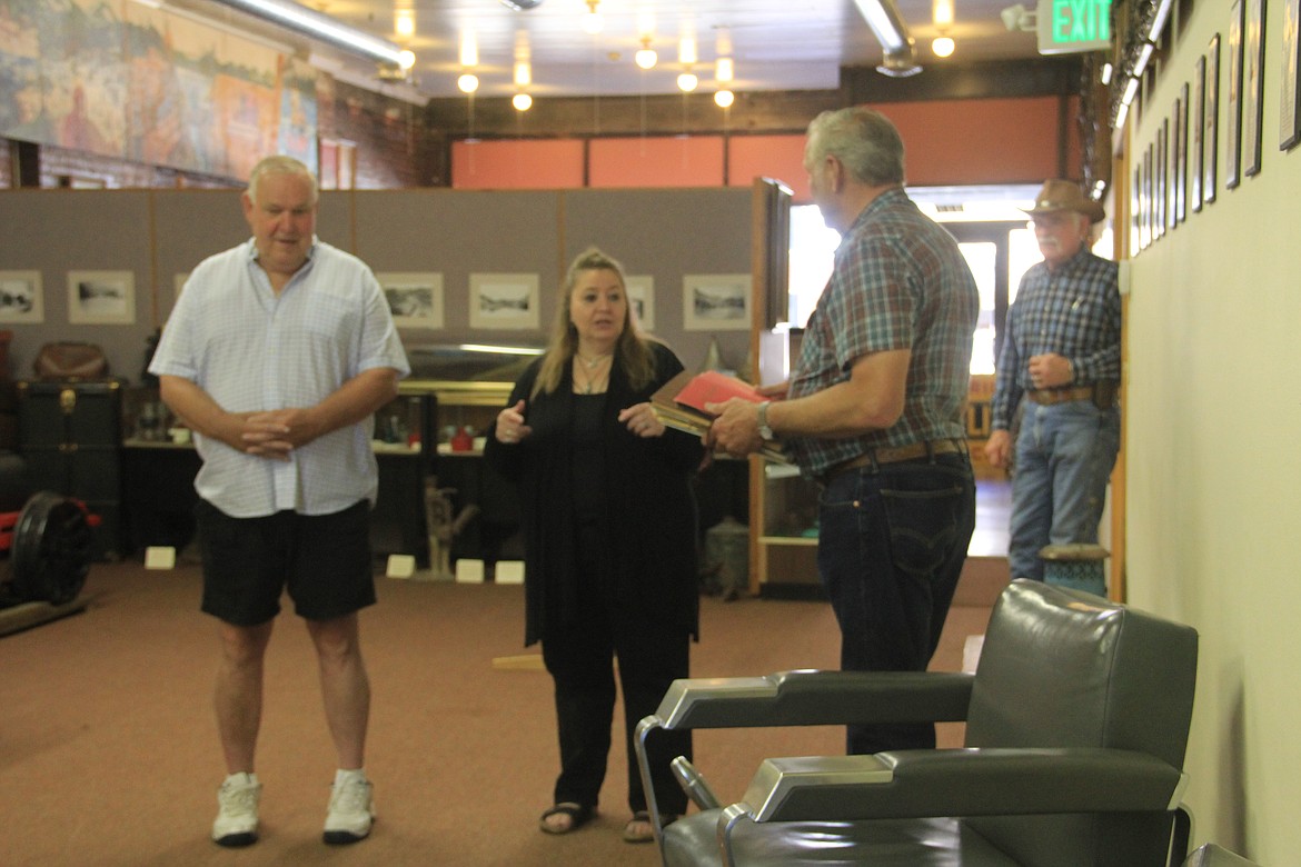 Ted Hudlow presents scrapbooks from the late Clara Hewett, a former teacher at Evergreen Elementary School, to Sue Kemmis.