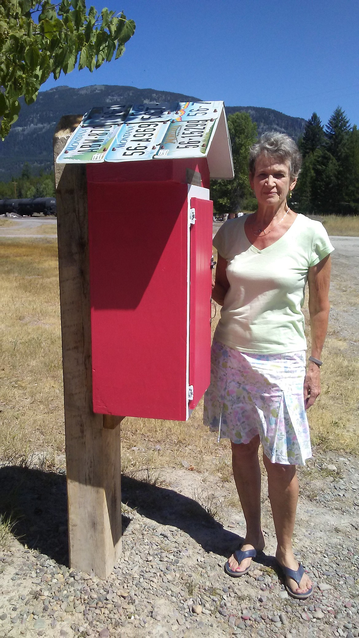 Judy Hulslander, pictured with the Little Free Library in Stryker, has led the effort to get similar small library book exchange kiosks set up in Trego and Fortine. The rural communities are located northwest of Whitefish.