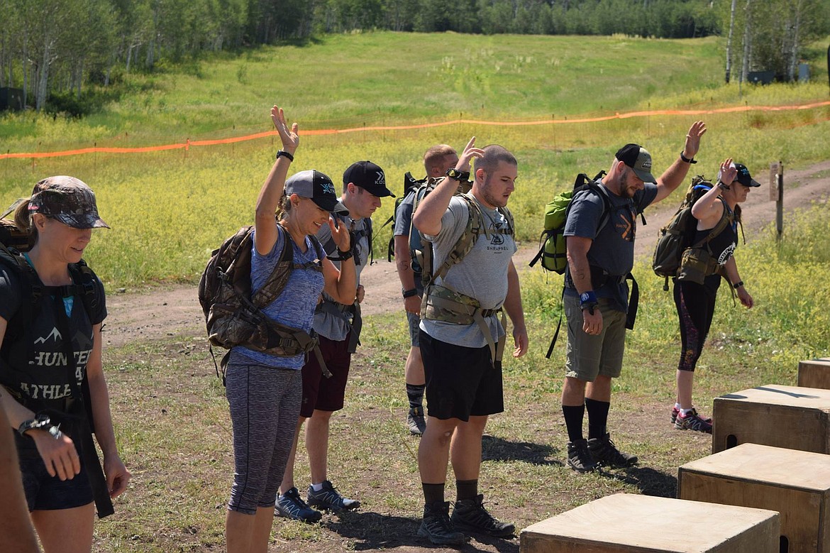 Starting Line of Event 1: Treva Rawlings is on the far left, anxiously waiting for the first event to start. This event was a combination of strength and endurance running with heavy weight and completing high repetition physical activities up and over the 20 inch box featured in the photo. They shot an arrow with an elevated heart rate at a 3D target between exercises.