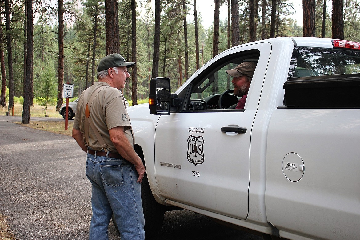 Jim Ward, Superior Ranger District, visits with Quartz Creek Campground host, Cliff Parker about closures due to the Sunrise Fire. (Kathleen Woodford/Mineral Independent).