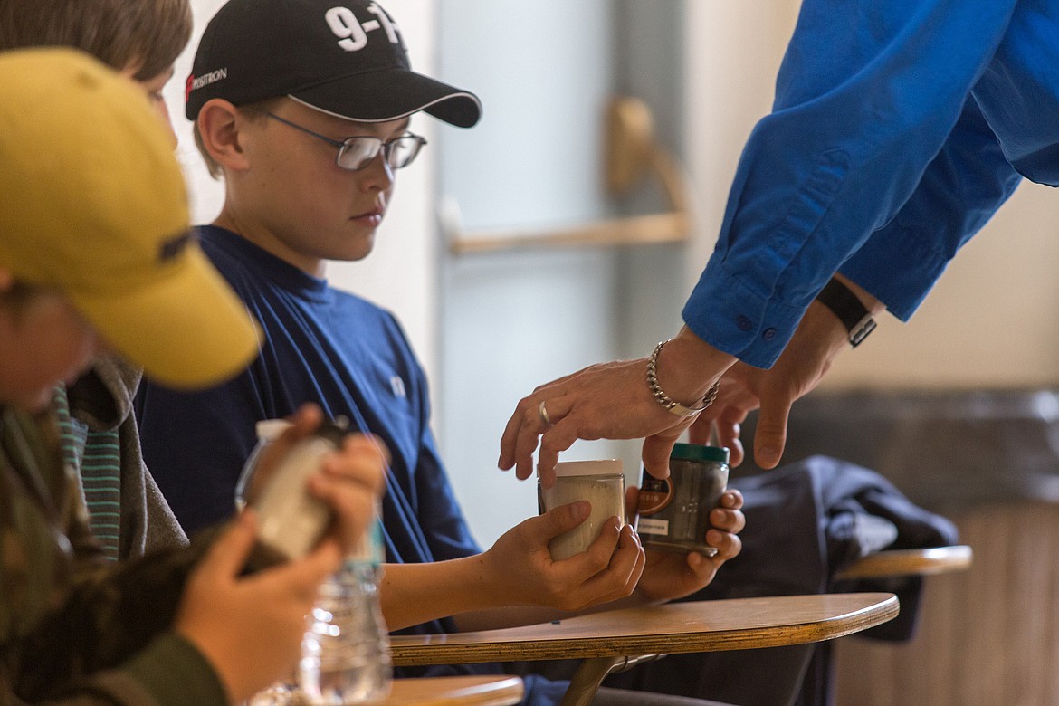 Troy student Mathew Gromley is given mining samples by Doug Stiles of Hecla Mining Company June 13, when Gromley and fellow students visited the Troy Mine as part of a summer science class field trip. (John Blodgett/The Western News)