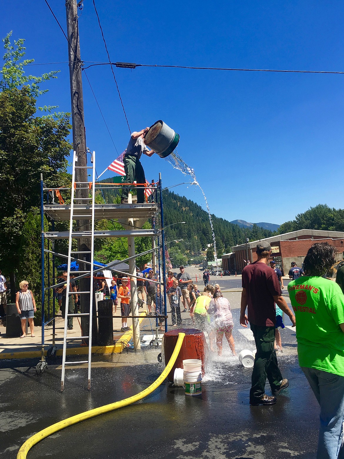 Photo by Jonnie Nelson.
Thats one way to cool off! A United States Forest Service team member gives some children a little respite from the heat.