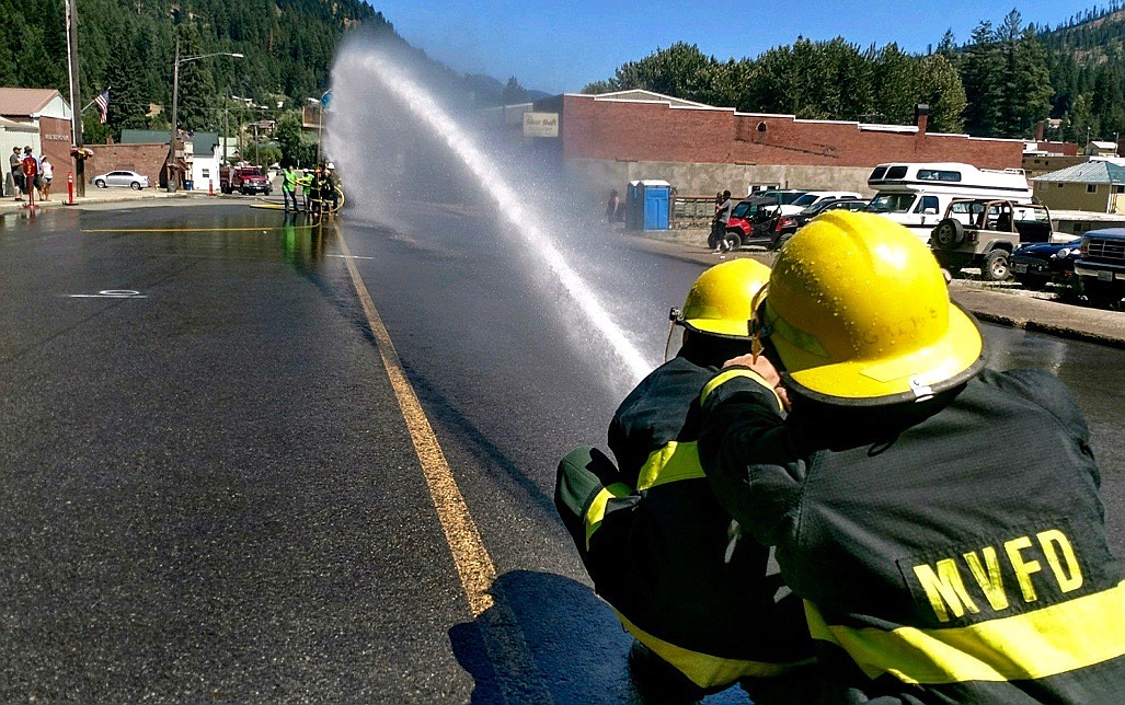 Photo by Larry Passantino. 
Tug-of-war participants in MVFD gear hold the hose steady.