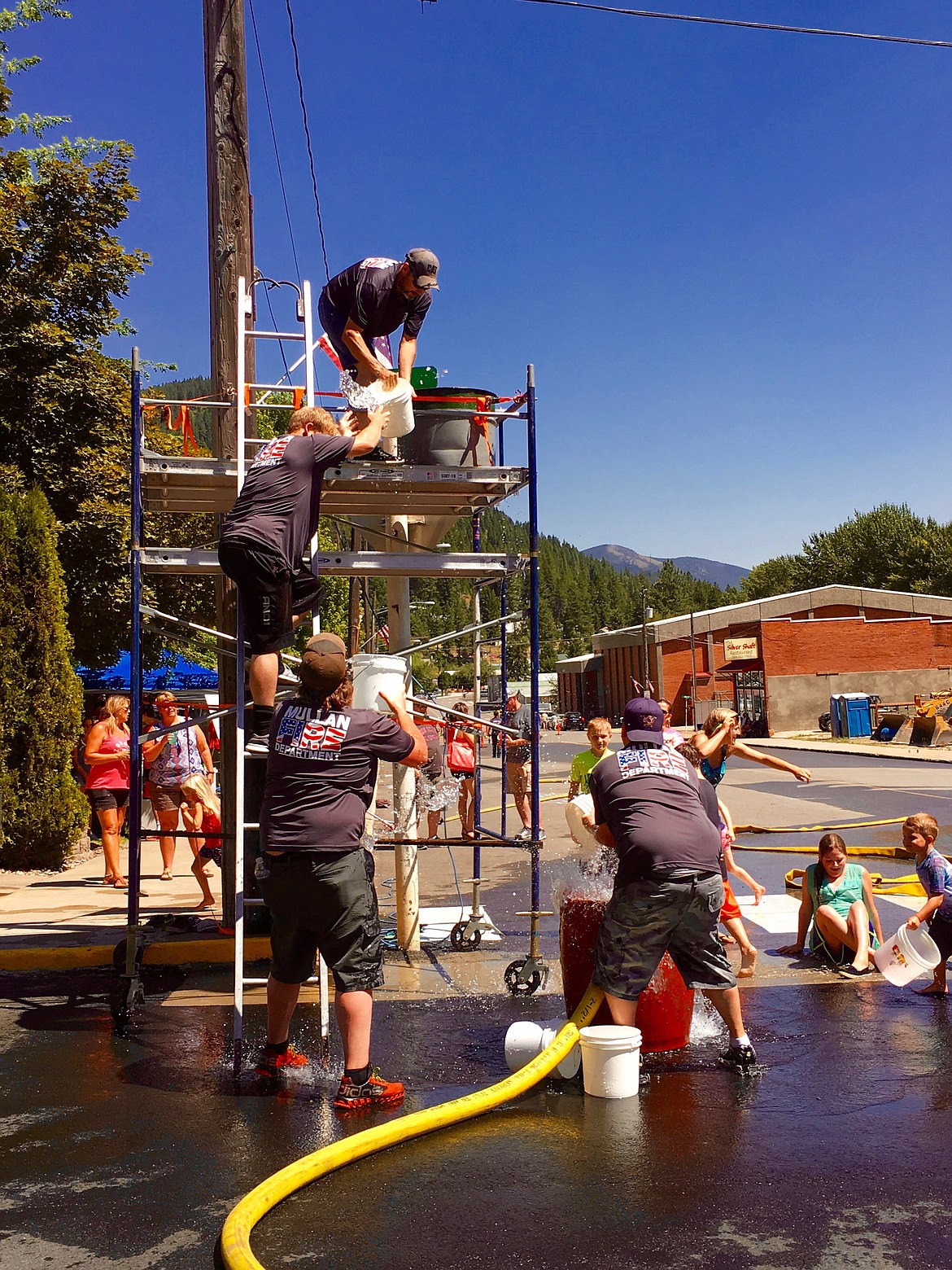 Photo by Larry Passantino.
The Mullan Volunteer Fire Department team (from top- Chris Morris, Pat Johnson, Dale Stepro Jr., and Dale Stepro) moves quickly in the bucket brigade challenge.