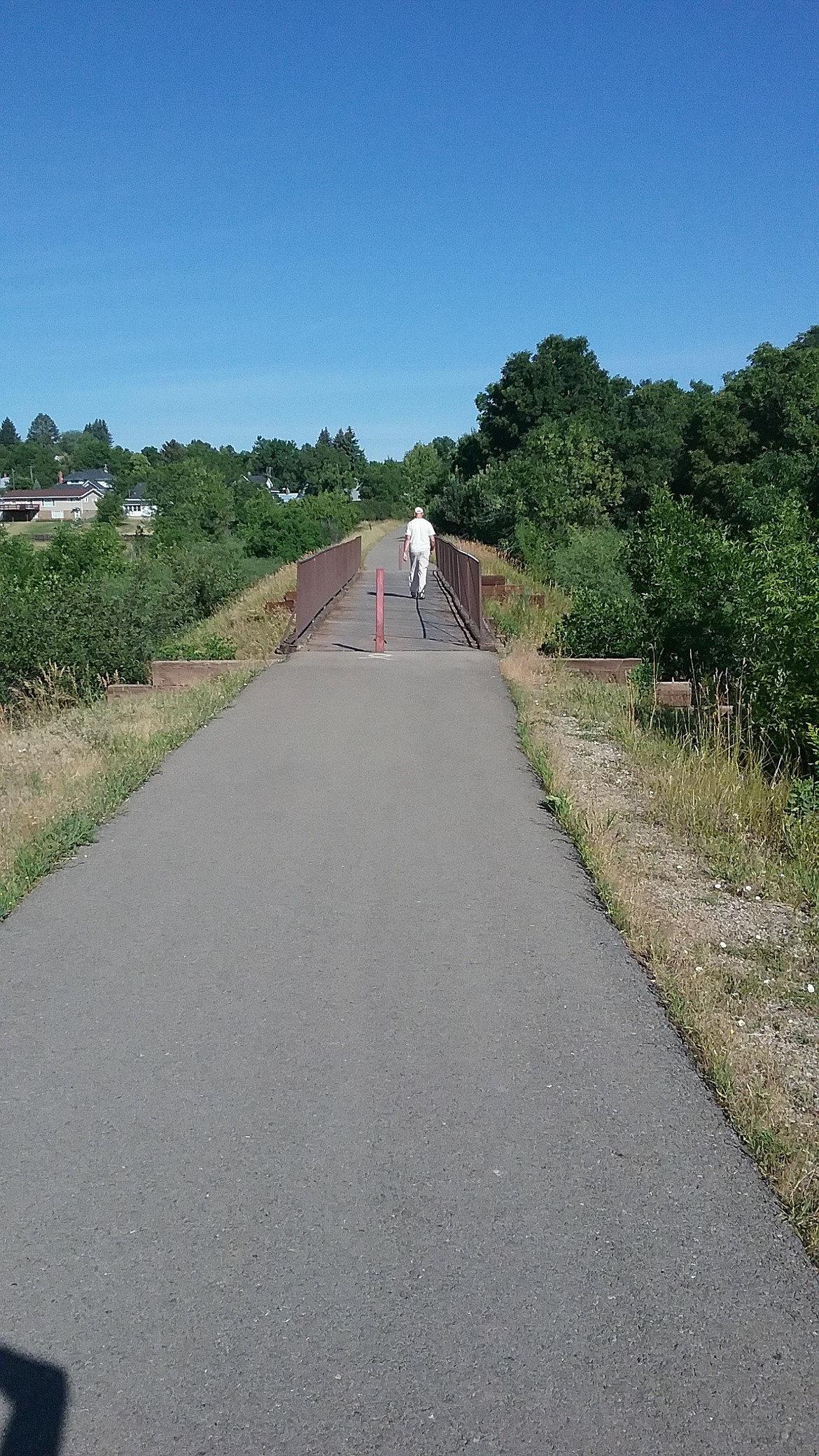 JERRY HITCHCOCK/Press
A man walks over a bridge near the Frog Ponds on the Lewistown Trail System.