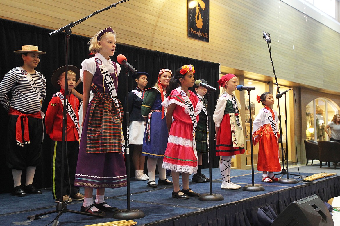 DEVIN HEILMAN/Press
Haley Nagel, 10, represents Iceland as she sings a part of &quot;Do-Re-Mi&quot; in the Plaza Shops during an International Peace Choir performance Thursday. Also at the mics are Karina Ruiz, 8, representing Mexico; Keira Cabenel-Bleuer, 9, &quot;Spain;&quot; and Zhizhen Chen, 6, &quot;China.&quot; The choir members, from southern California, recorded an album at a studio in Athol this week and performed at three locations during their stay.