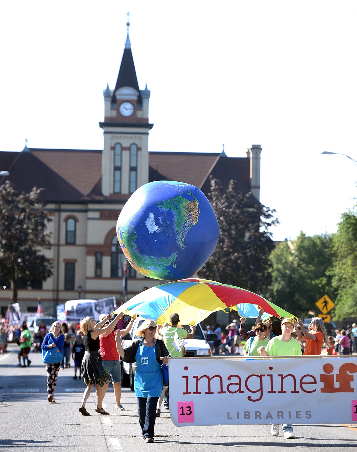 ImagineIF staff members and their families proceed down Main Street while throwing and catching a giant globe on Friday, August 18, in the 2017 Northwest Montana Fair Parade. When asked about the meaning of the float Megan Glidden of ImagineIF said, &#147;We do have opportunities for people to see the world in a whole new way here at the library.&#148;
(Brenda Ahearn/Daily Inter Lake)