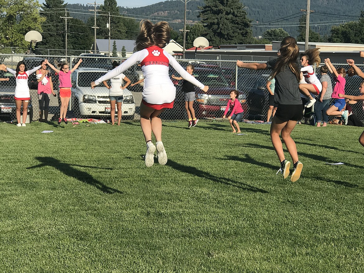 (Photo by K.J. JOHANSEN)
Sandpoint High School cheerleaders served as mentors while teaching jumps in the debut season for the SAFL youth cheer, as the excitement was heard from across the field. Youth cheerleaders squads from 3rd/4th grade and 5th/6th grade were already in formations and you could hear &#147;Go Bulldogs Go&#148; from the loud little voices. Director of Coaching, Sara Garrison, was humbled by the support of not only the SHS cheer team, but also the SHS dance team and parents who were willing to offer assistance. &#147;The community coming together to support these cheerleaders is our why,&#148; said Garrison.