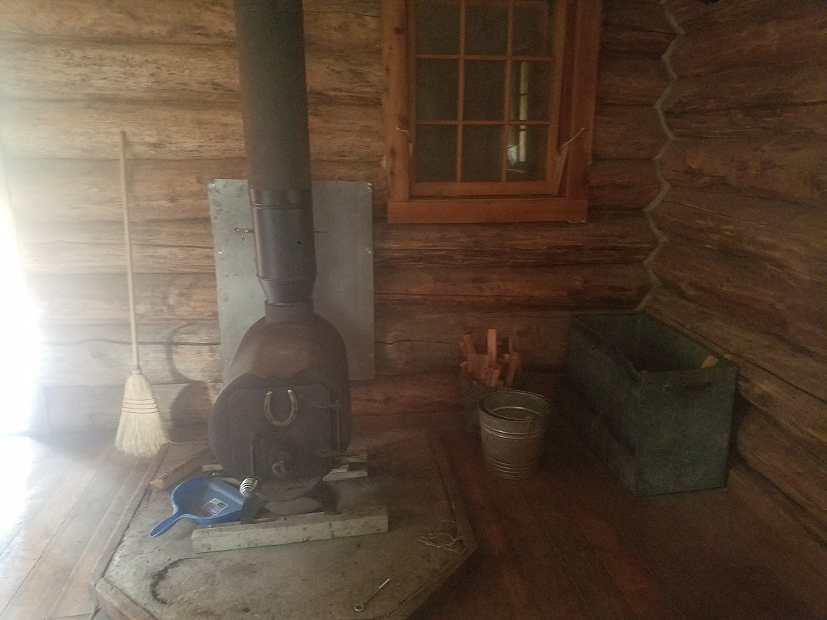 Photo by Tanna Yeoumans
The wood stove in the cabin received a backsplash that reduces the chance of fire, and the new chimney pipe leading to the ceiling. The pictured window has a table that folds down onto the porch that also got a new metal finish, which reduces the wear on the tabletop itself.