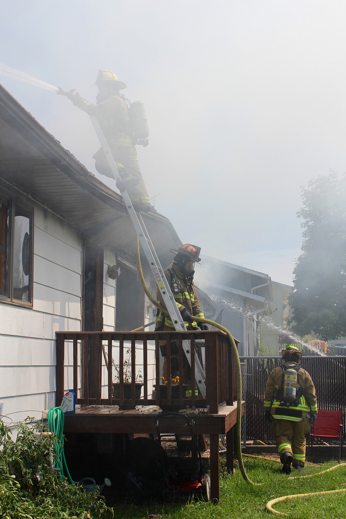 A view of fire crews getting up close to the home with a hose and ladder so they can attack the blaze from above.