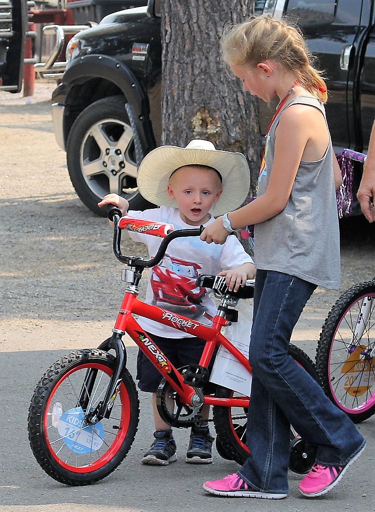 Travyn Thornton, 3, from Niarada near Hot Springs is surprised at a new bike he won during the Mineral County Fair. (Kathleen Woodford/Mineral Independent)