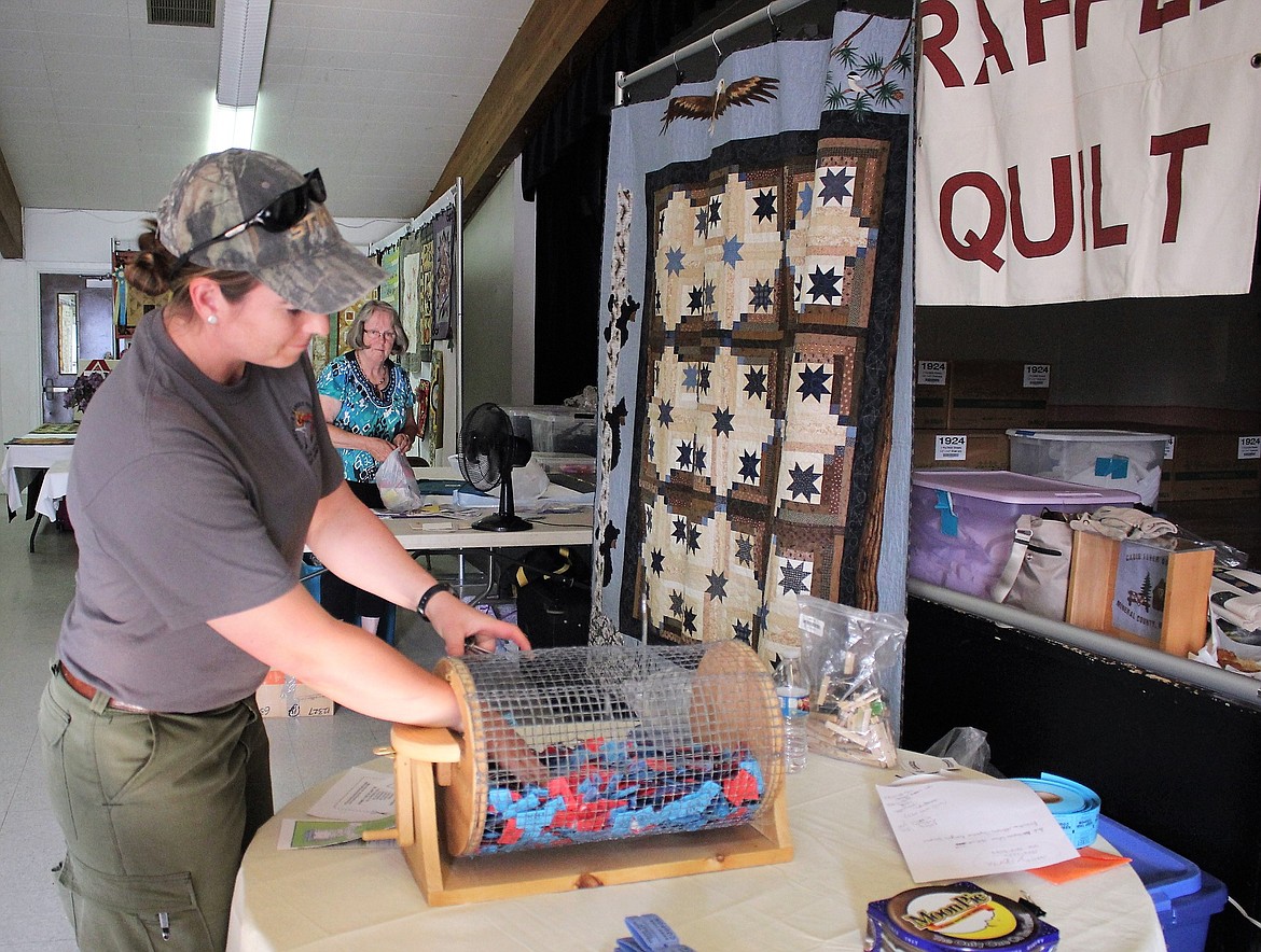 Andi Colson with the Forest Service, pulls the winning raffle ticket during the Cabin Fever Quilters 7th Annual Quilt Show in Superior. (Kathleen Woodford/Mineral Independent).