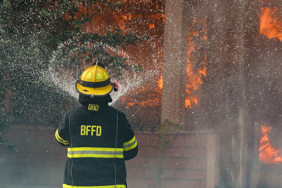 Photo by Mandi Bateman
Water meets fire: Bonners Ferry Firefighter keeps control of the live burn.