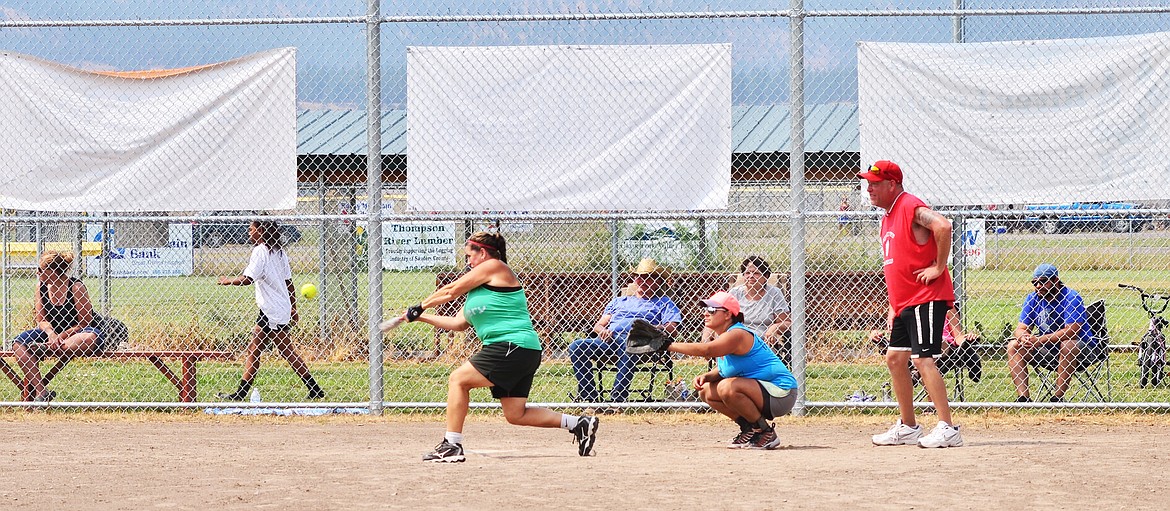 Crystal McDonald batting for The Printery, Rose Wagoner catching for Studds with Jon Zigler as umpire. Photo Credit Erin Jusseaume Clark Fork Valleyh Press