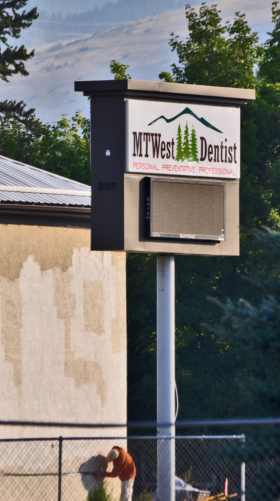 A contractor works on the exterior now that the new sign is erected. (Erin Jusseaume/Clark Fork Valley Press)