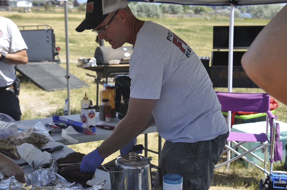 Polson Fire Chief Clint Cottle cuts brisket during the July 29 Smokin&#146; on the River event, held by the Polson Fair Board at the fair grounds. (Ashley Fox/Lake County Leader)