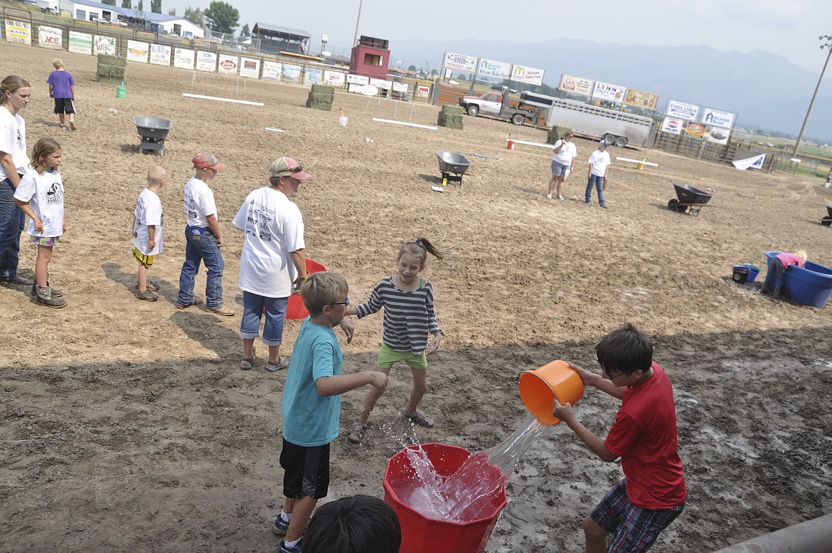 Kids take part in a challenge Saturday afternoon at Ronan Pioneer Days. Four teams with five people had to fill tubs of water, with the team doing so first, winning. Everyone received participation certificates for ice cream.