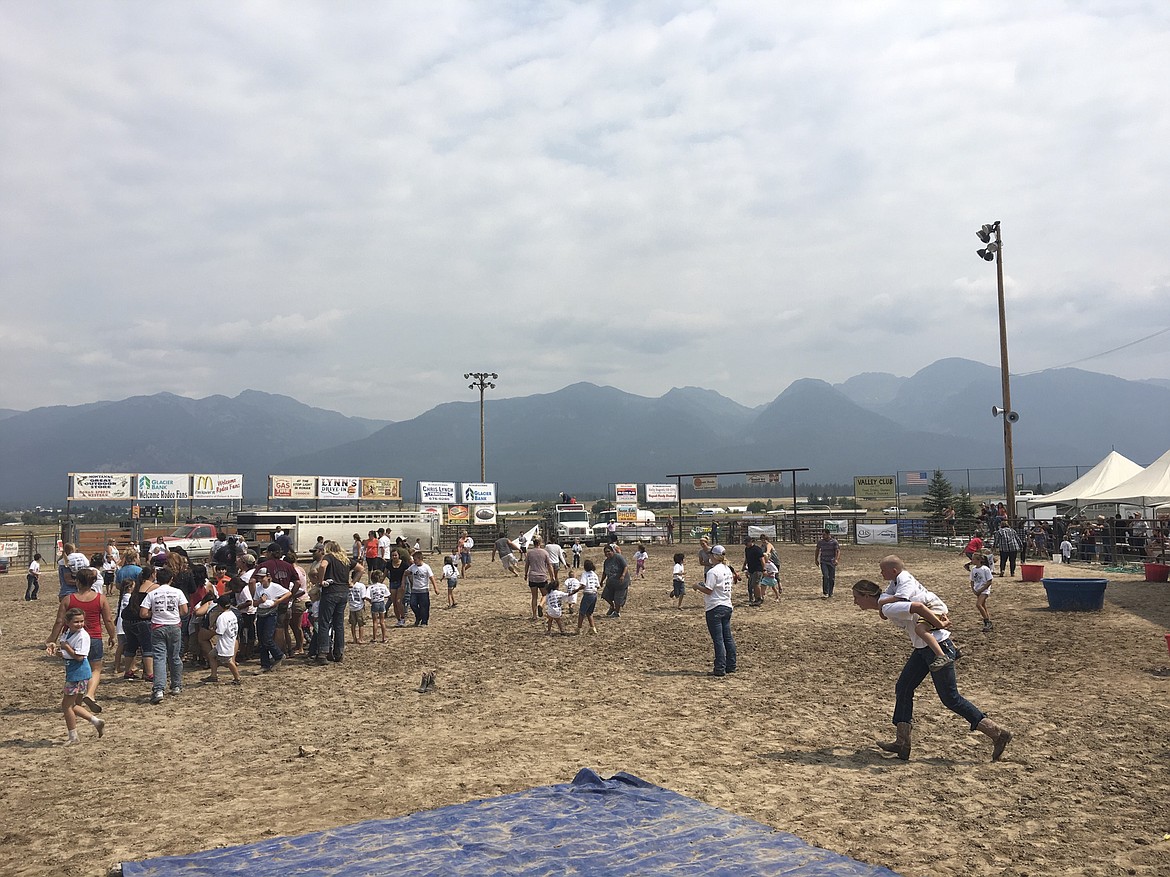 Parents scurry to find their kids-wearing the same white shirt and with fists full of candy-on Saturday during a scramble for the Kiddie/City Slicker Rodeo at Ronan Pioneer Days.