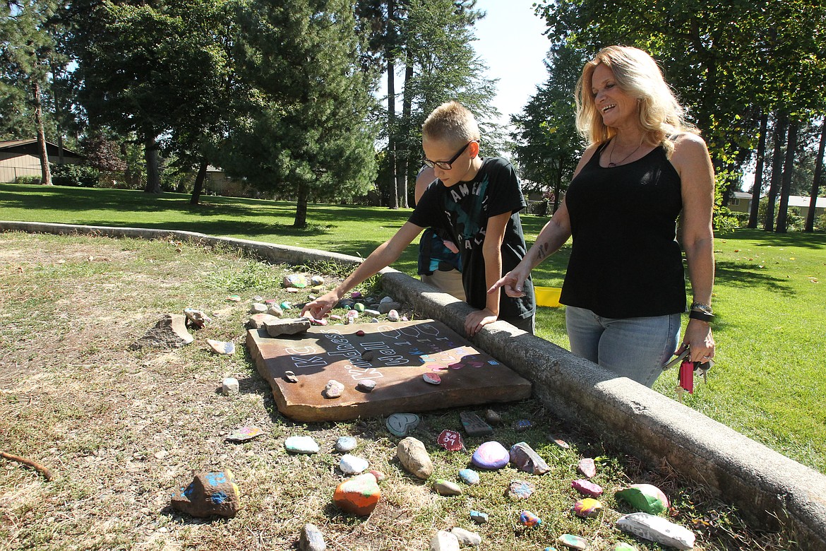 DEVIN HEILMAN/Press
Debby Carlson of Post Falls and son Aidan, 12, scope out some of their favorite rocks Friday at the new Kootenai County Kindness Wall in White Pine Park in Post Falls. The wall was arranged by organizers of the new rock painting/hiding group, KC Rocks, for little kids and those with disabilities who cannot easily go out and hunt for cleverly hidden rocks.