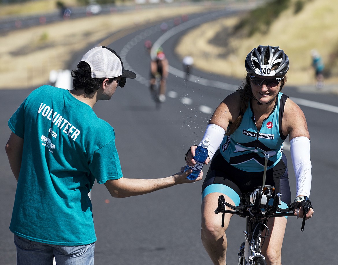 LOREN BENOIT/Press

Hunter Northington hands a water bottle to Robin Deruwe Sunday afternoon during Ironman Coeur d&#146;Alene.