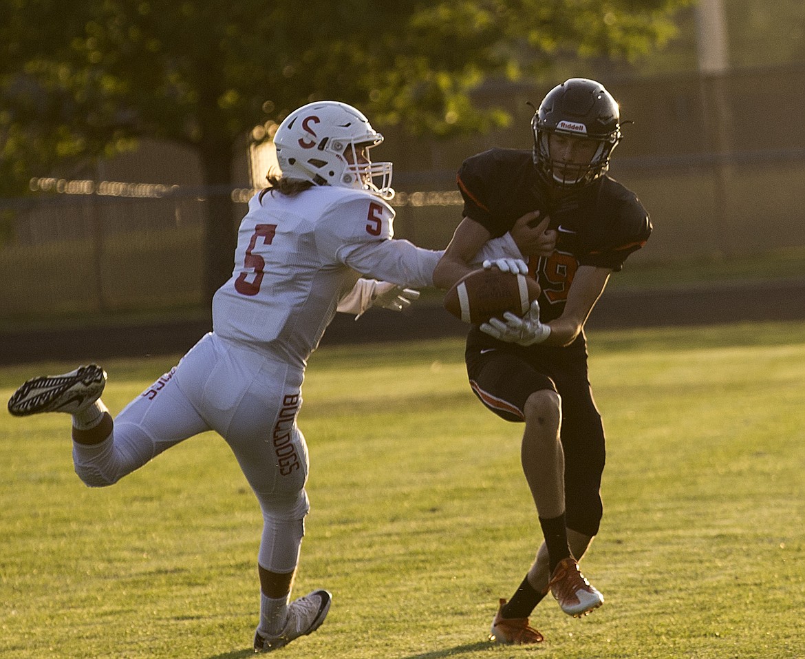 LOREN BENOIT/PressPost Falls wide receiver Allen Ballew catches a deep pass versus Sandpoint's Sam Diercks during Friday's game at Post Falls High School.