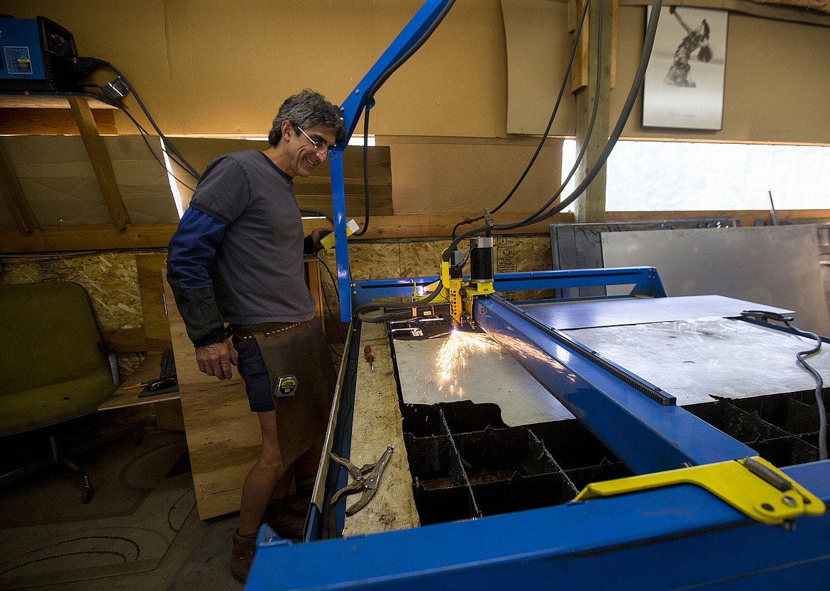 LOREN BENOIT/PressRodkey Faust uses a plasma cutter to make a handrail component Wednesday afternoon at his workshop in Twin Lakes.