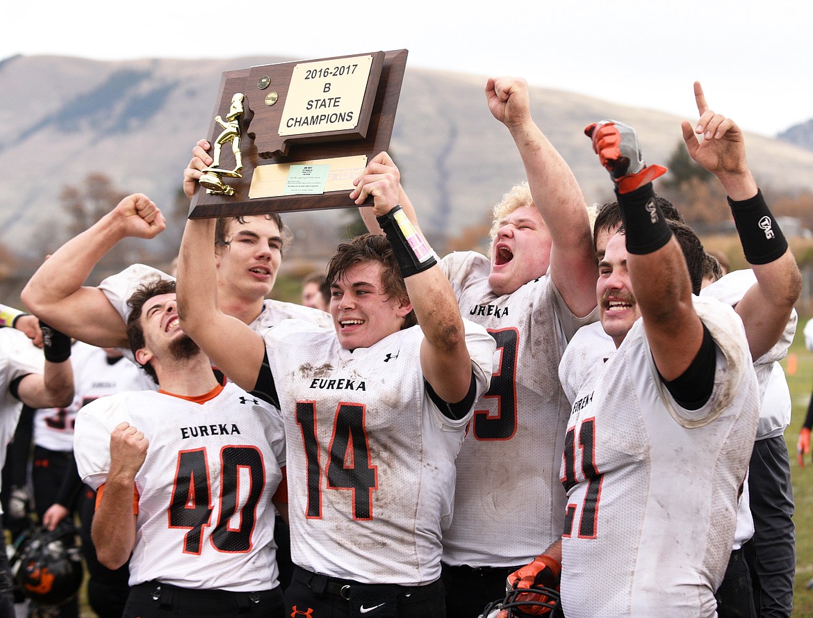 The Eureka Lions hold up the plaque for their first state title after defeating Missoula Loyola 31-28 on a Hail Mary as time expired in the Class B Championship at Loyola on Saturday. (Aaric Bryan/Daily Inter Lake)