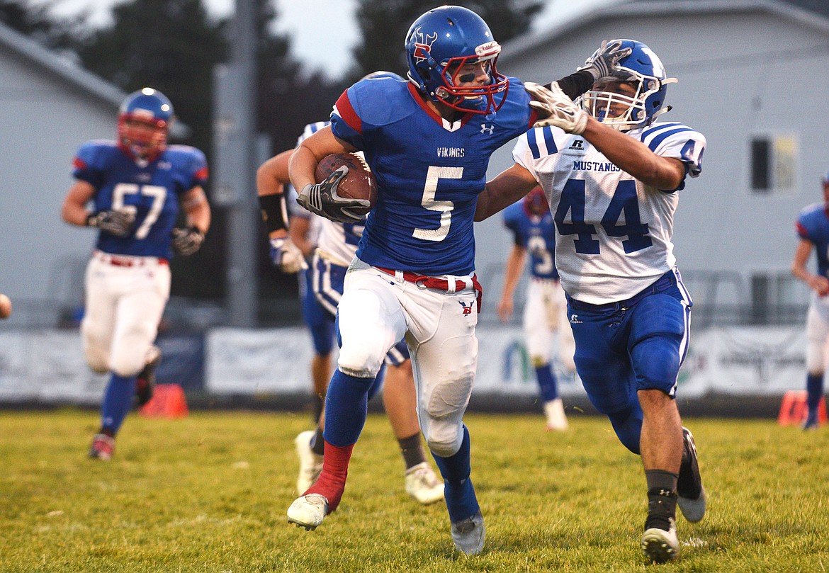 Bigfork wide receiver Anders Epperly straight arms Malta linebacker Andres Lopez during the first quarter in Bigfork on Friday. (Aaric Bryan/Daily Inter Lake)