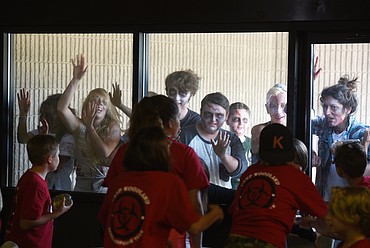 Zombies bang against a window at the Woodland Park Center in Kalispell during Zombie Survival Camp on Wednesday.