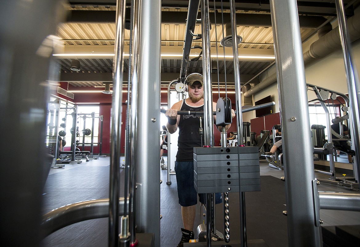 LOREN BENOIT/Press
North Idaho College student Devon Cole works on his biceps using the pulldown bar Wednesday morning at the new wellness and fitness center on NIC&#146;s campus.