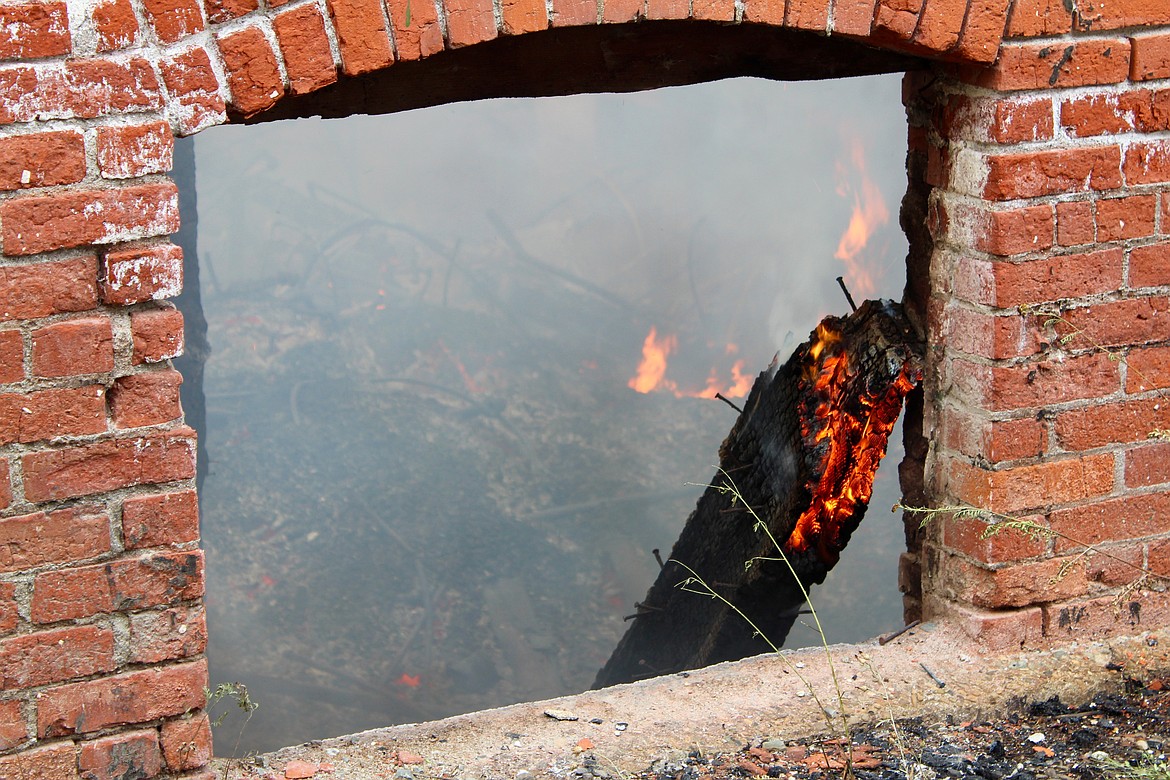 Photo by Chanse Watson/
A view of the McConnell Hotel's basement. A wooden support beam crackels with flames.