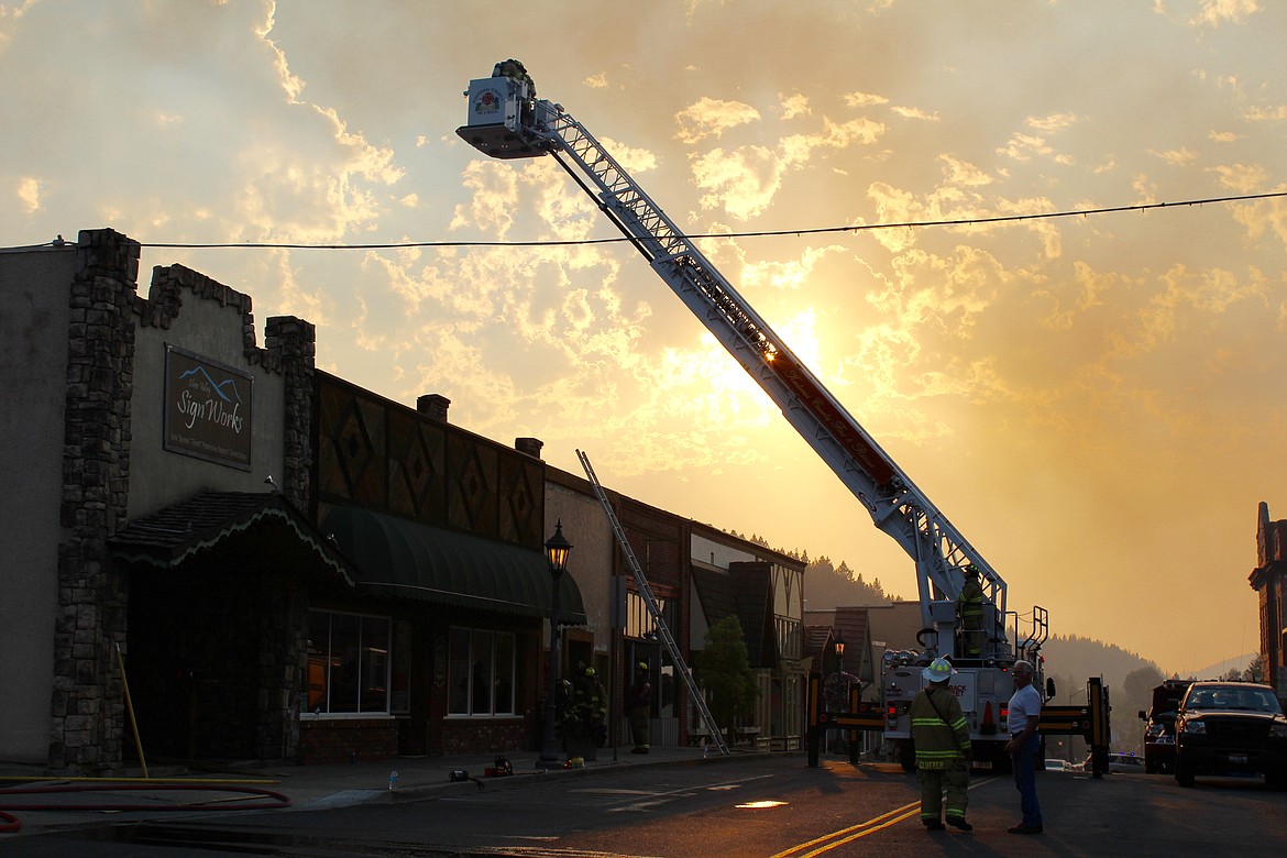 Photo by Chanse Watson/ 
Kootenai County Fire &amp; Rescue's ladder truck prepares to hose down roofs in uptown with the sun setting in the background.