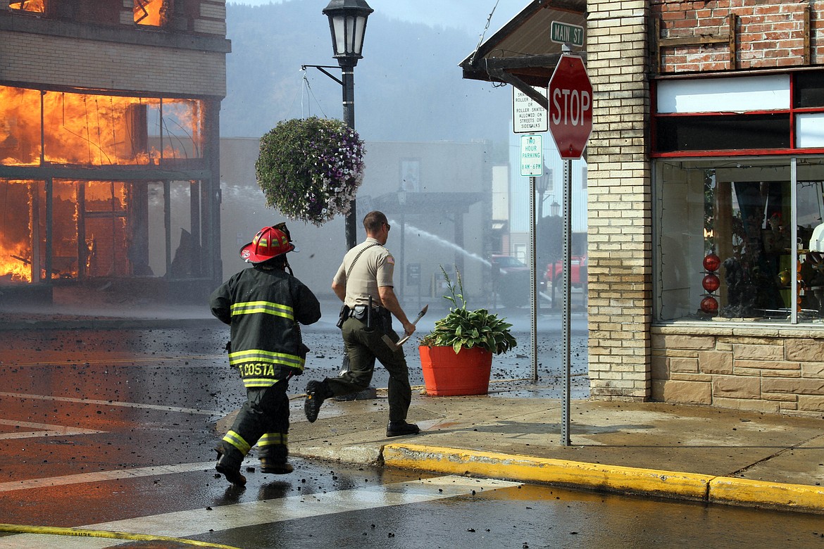 Deputy Jeremey Groves and firefighter Travis Costa run to evacuate people in adjacent buildings.