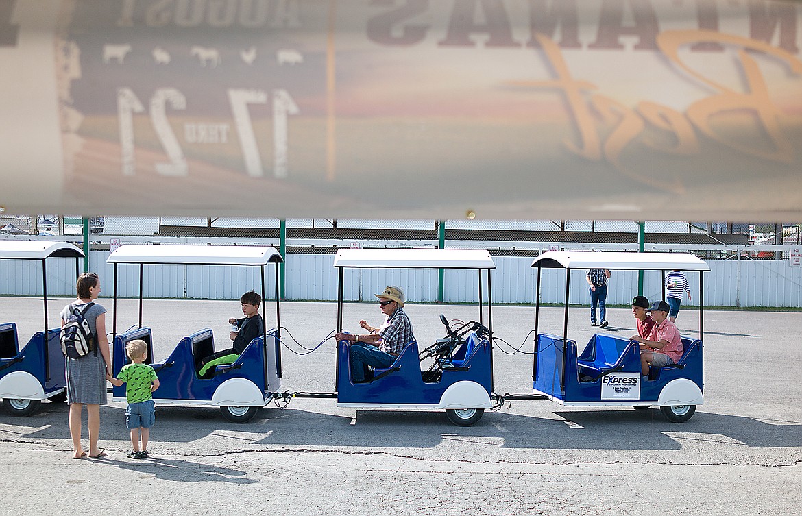 A mother and child wait for a train ride through the fair lasy week.