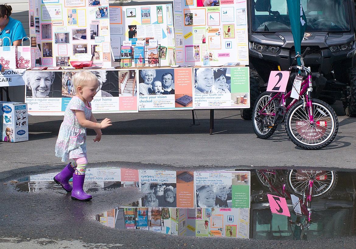 Charlotte Moore plays in the puddles at the Montana Fair last week.