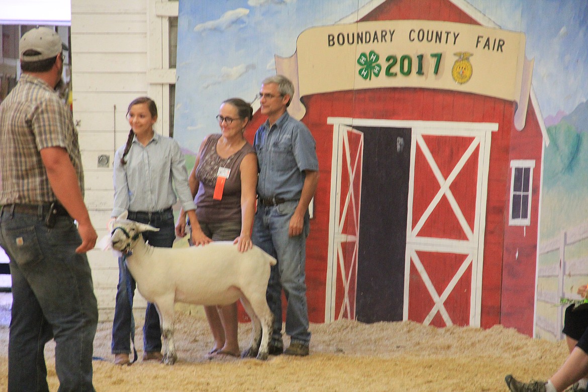 Photo By Tanna Yeoumans
Ayla Worley poses for a picture with her lamb and buyers from EL Internet/Bamboo Room.