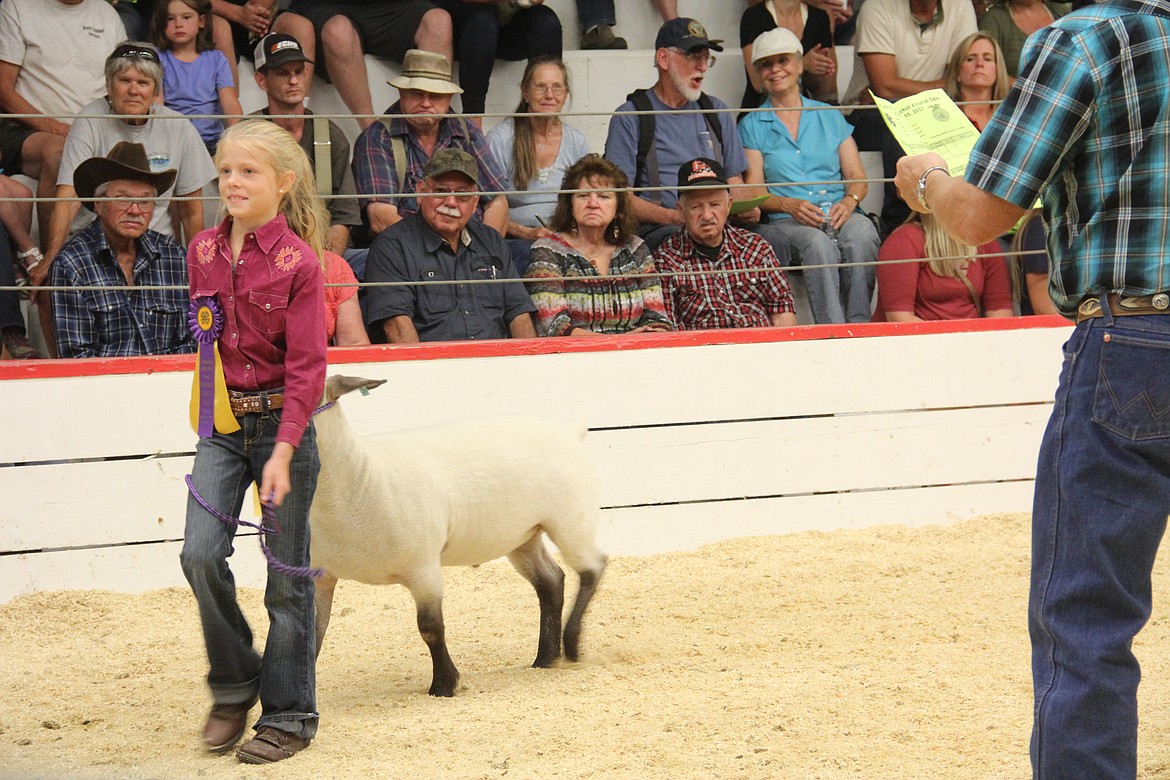 Photo By Tanna Yeoumans
Lillian Bremer displays her Champion ribbon and lamb.