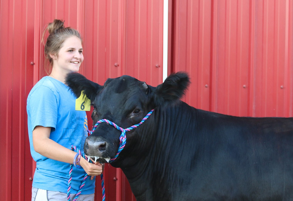 Photo by Mandi Bateman
Mercedes Hill poses with her cow for one last photo, since was sold the day before at the auction.