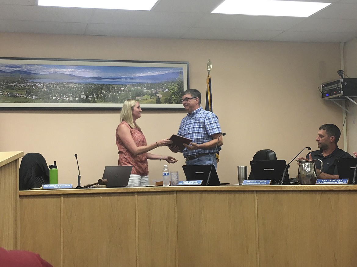 Polson Mayor Heather Knutson, left, hands Ward 1 Commissioner Todd Coutts a plaque for his service for the last 20 months during the Aug. 21 meeting.