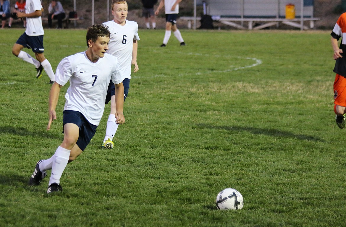 Dakota Nielsen sends a ball through the Priest River defense as Blake Copeland stands by to offer assistance if needed.